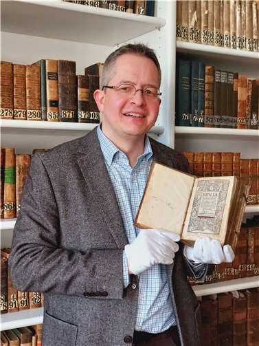 Dr. Marco Brösch zeigt die Bibel. Foto: Pia Pastor, St. Nikolaus-Hospital/Cusanusstift Bernkastel-Kues