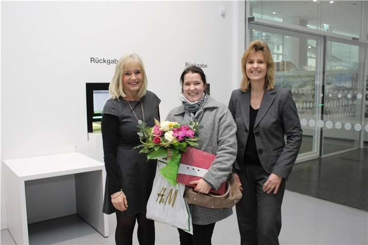 Dr. Margit Theis-Scholz, links, und Bibliotheksdirektorin Susanne Ott rechts, überraschten Vanessa Lux mit Blumenstrauß und Geschenk. privat