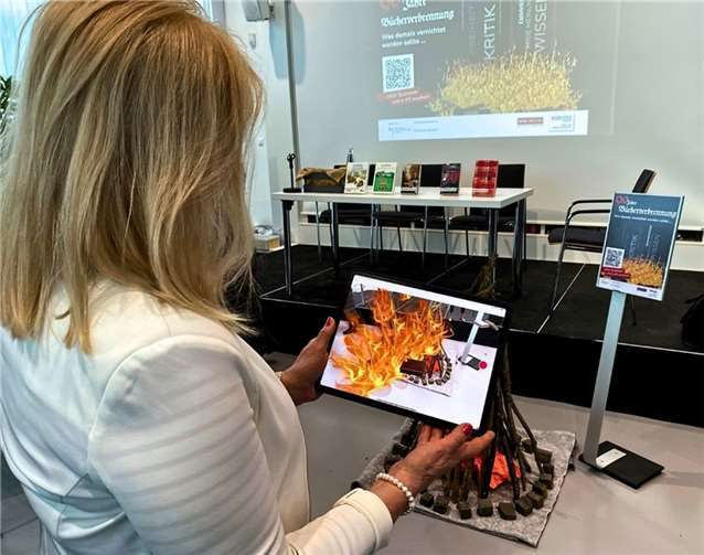 Dr. Margit Theis-Scholz zeigt die animierten Flammen der Bücherverbrennung. Fotos: Stadt Koblenz/Mandy Steffens