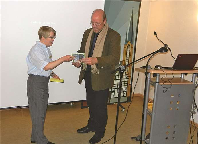Dr. Maria Burger überreicht Dr. Jens Friedhoff zur Erinnerung an den Vortragsabend eine Broschüre von Odendorf.privat