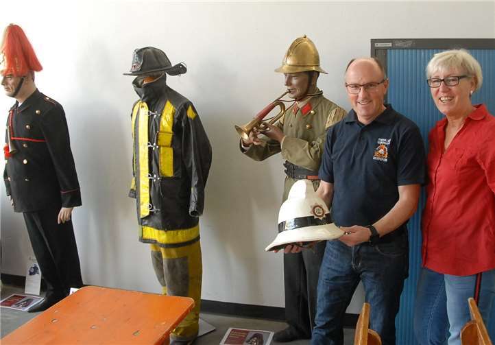 Dr. Moritz Jungbluth aus Nauort stellte die historischen Feuerwehruniformen für eine kleine Ausstellung zur Verfügung. Hier erklärt ein Mitglied der Feuerwehr Oberdreis einer Frau die einzelnen Teile der Ausrüstung.