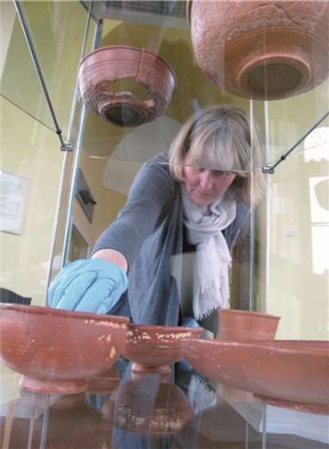 Dr. Susanne Willer vom LVR-Landesmuseum Bonn begutachtet die Bestückung der neuen Sechseckvitrine im Heimatmuseum Sinzig mit Terra Sigillata, die ursprünglich aus Sinzig stammt, sich aber in den letzten 100 Jahren in Bonn aufhielt.Denkmalverein