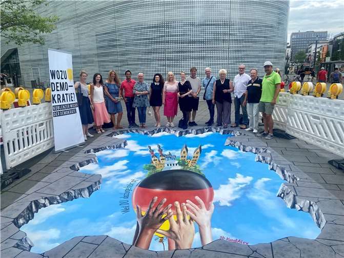 Dr. Theis-Scholz, Dezernentin für Bildung und Kultur, begrüßt Kooperationspartner*innen und Interessierte zum 3D-Streetpainting im Rahmen der Koblenzer Wochen der Demokratie. Neugierige können sich das Werk von Alexander Petscherskich noch bis zum 30. Juni auf dem Zentralplatz ansehen.  Foto: Stadt Koblenz/Martin Düpper