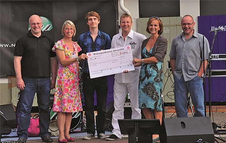 Dr. Wolfgang Voss (in weiß) überreicht den beiden Damen der Krebshilfe den Scheck: Andrea Jünemann (2.v.l.) und Antje Kernchen (5.v.l.). RÜ