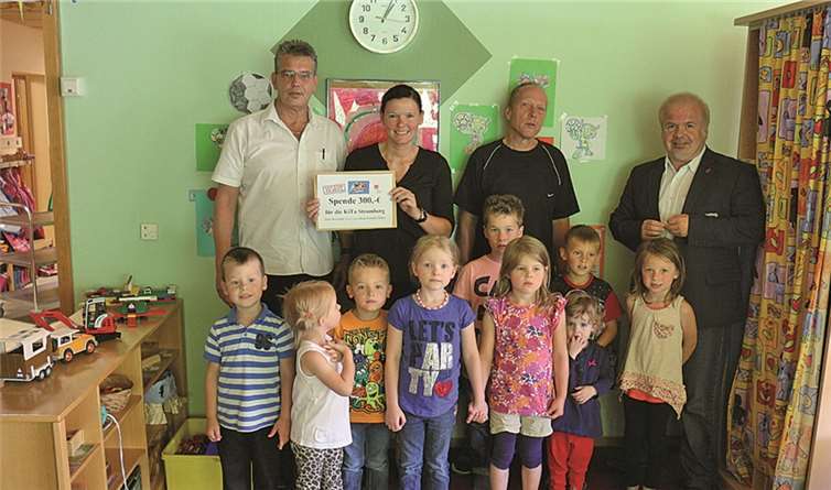 Drei Vertrauensleute der Gewerkschaft sind im Kindergarten Stromberg bei der Scheckübergabe in Höhe von 300 Euro, (v.l.) Ralf Schneider, Stefanie Schmidt, Ralph Sommer und Ferhat Cato und die Kinder der Einrichtung. privat