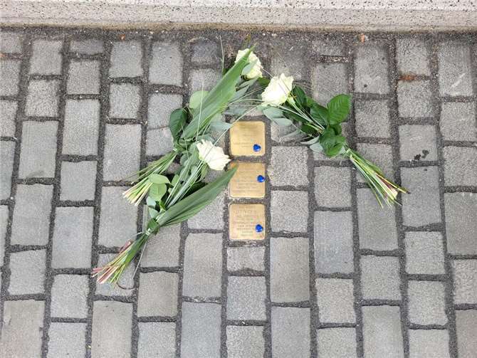 Drei weiße Rosen wurden an den Stolpersteinen der Familie Stern niedergelegt. Die Enkelkinder Marnie (7), Koby (9) und Ethan (13) ergänzten drei blaue Herzen zum Andenken an ihren Urgroßvater.