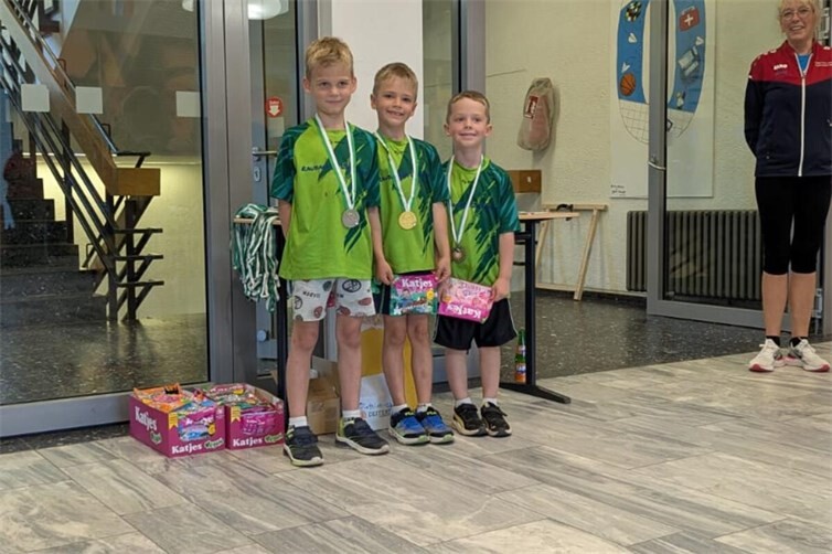 Dreifacherfolg für die SGi Raubach: Die drei erfolgreichen Nachwuchsschützen der Klasse Kinder C männlich freuen sich gemeinsam mit ihrer Trainerin über ihre Medaillen beim Finale des Rheinland-Cups 2026 in Neuss-Reuschenberg. Adrian Dix, Vito Dix und Carlo Gerhard belegten dabei die Plätze eins bis drei.