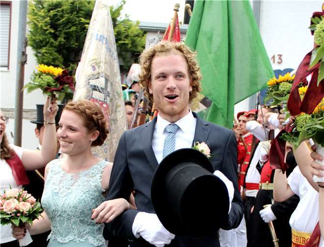 Durch das Spalier der Offiziere und der Sonnenblumenschwenkenden weiblichen Mitglieder des Junggesellenvereins schritten Tobias Wallek und Nadja Wester ins Freie.