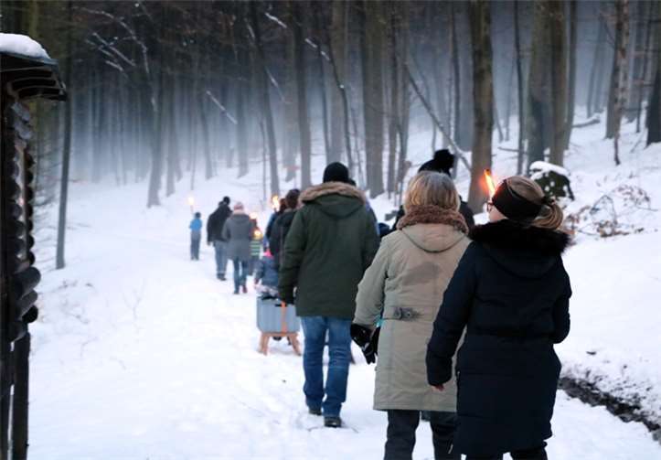 Durch den Nebel schreiten die Fackelträger im Dämmerlicht durch den Wald. Wie verzaubert erschien ihnen die Natur.
