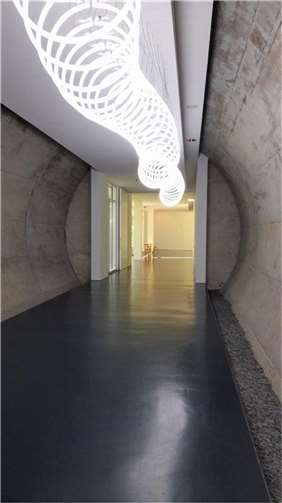 Reisen ohne Koffer ins Arp-Museum Durch einen mit einem Lichtkunstwerk beleuchteten Museumsgang, der als Durchgang unterhalb des Bahnhofs verläuft, gelangte die Gruppe zu einem Aufzug, der in die oberen Stockwerke des Zusatzbaus des Museums führt.