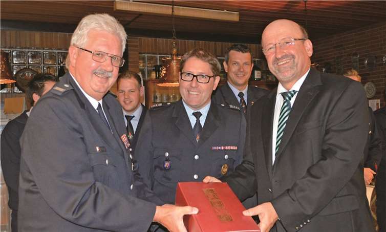 Eduard Krahe (M.,) wird von Bürgermeister Herbert Georgi (r.) und Stadtwehrleiter Michael Zimmermann als Fachberater der Feuerwehr-Einsatszleitzentrale verabschiedet. AB