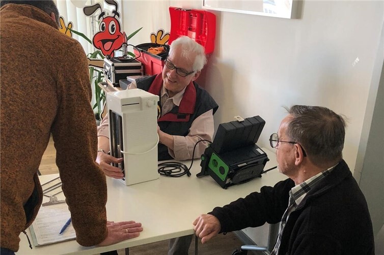 Ehrenamtlicher Reparateur bei der Sichtprüfung eines defekten Toasters