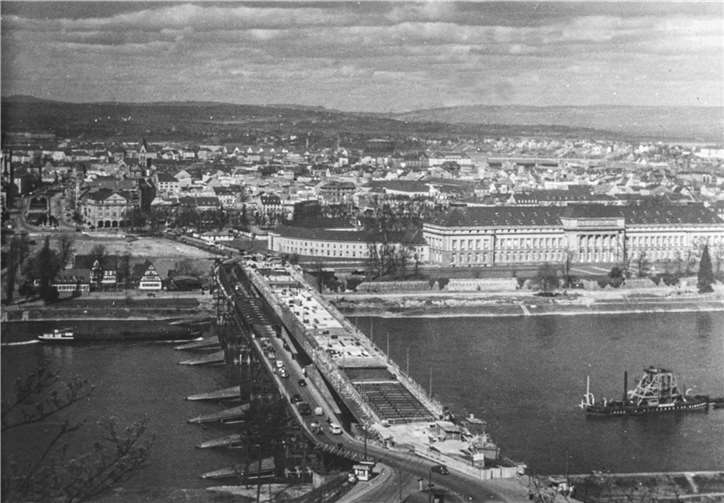 Ein Blick im Frühjahr 1953 vom Asterstein in Richtung Koblenzer Schloss während der Bauarbeiten zur neuen Pfaffendorfer Brücke, die zwischen 1950 und 1953 erbaut wurde. Auf der linken Seite neben dem im Bau befindlichen neuen Bauwerk ist die 1946 errichtete Behelfsbrücke zu sehen.  Foto: Heinrich Wolf
