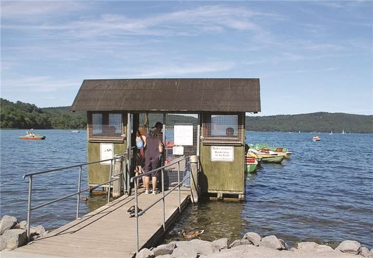 Ein Bootsverleih in unmittelbarer Nähe der Abtei Maria Laach lädt zum Paddeln auf dem Laacher See ein.