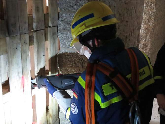 Ein Jugendlicher sägt den versperrten Zugang zum Verletzten auf. Foto:THW Ahrweiler, Arnulf Czerwinski