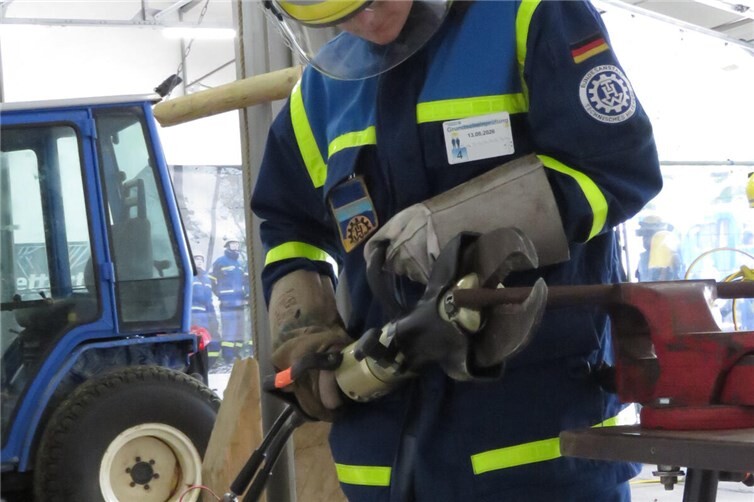 Ein Prüfling schneidet ein Rohr mit einer hydraulischen Schere durch.