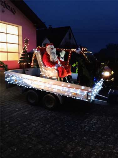Ein Quad zog einen Anhänger, auf dem der Weihnachtsmann Platz genommen hatte.