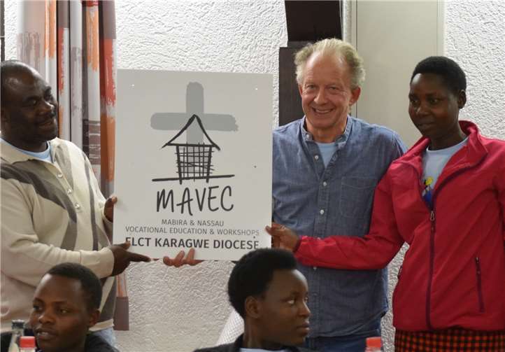 Ein Schild überreichte Dietmar Menze in Kördorf an die MAVEC-Auszubildende Rosinatha und Pfarrer Mambo, das das vom Arbeitskreis mit erbaute Ausbildungshaus in Mabira zieren soll.