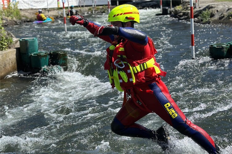Ein Strömungsretter beim Sprung in den Wildwasserkanal 