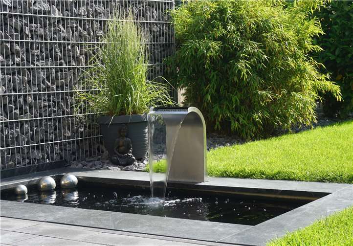 Ein Wasserspiel verzaubert den Rasen in eine stilvolle Oase der Besinnung.