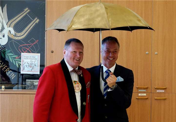 Dat es Nouert: Narhallamarsch im Juli Ein bisschen Schabernack muss sein: Heinz Kuppler übergibt Michael Merz einen goldenen Schirm für die Übernahme der Schirmherrschaft.