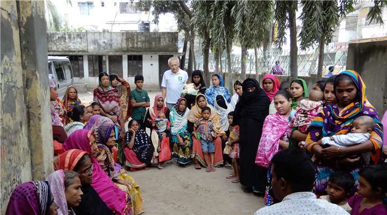 Ein einheimischer Mitarbeiter (vo.) hält im Beisein von Dr. Johannes Decker (hi.) eine Gesundheitsschulung ab.Dr. Johannes Decker