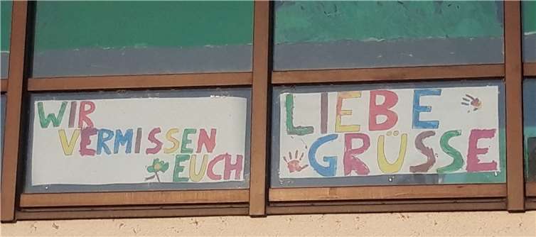 Ein farbenfrohes Banner im Fenster sendet Grüße.