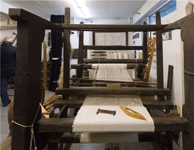 Ein historischer Webstuhl mit Kamm und Webschiffchen.