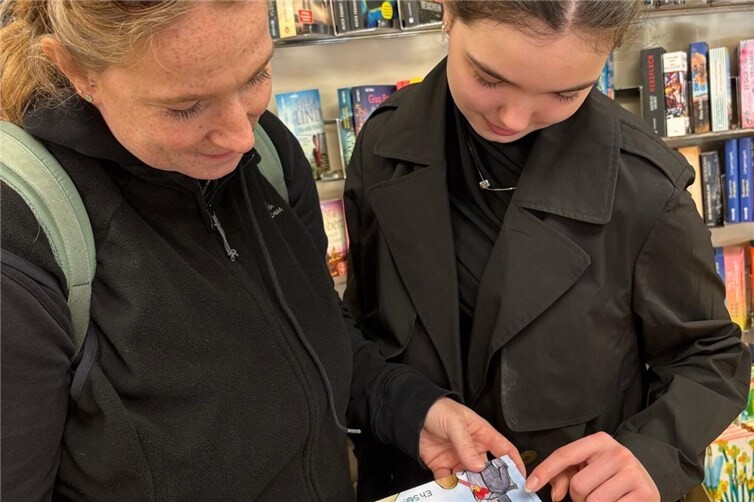 Ein interessierter erste Blick ins neue Buch - Besucher des Frühlingserwachens im Waldecker-Spielen und Schenken