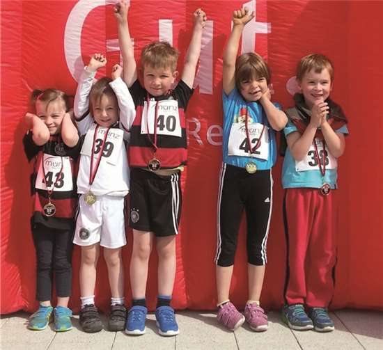 Ein paar der Bambini nach ihrem 200 m Lauf vor der Siegerehrungswand.