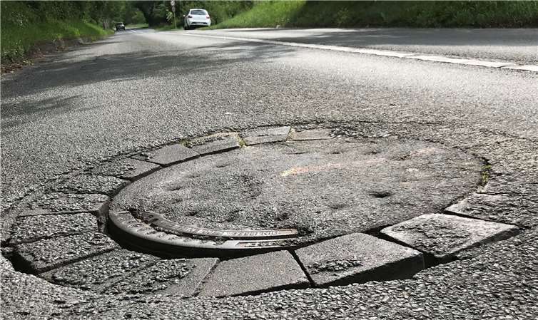 Ein schadhafter Kanaldeckel auf der K 14.privat