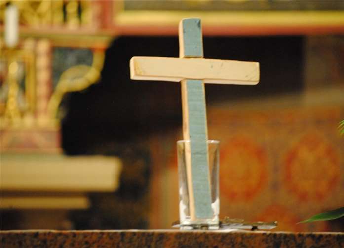 Ein schlichtes Holzkreuz auf dem Altar, das von einem vor Lampedusa gekenterten Boot stammt.privat