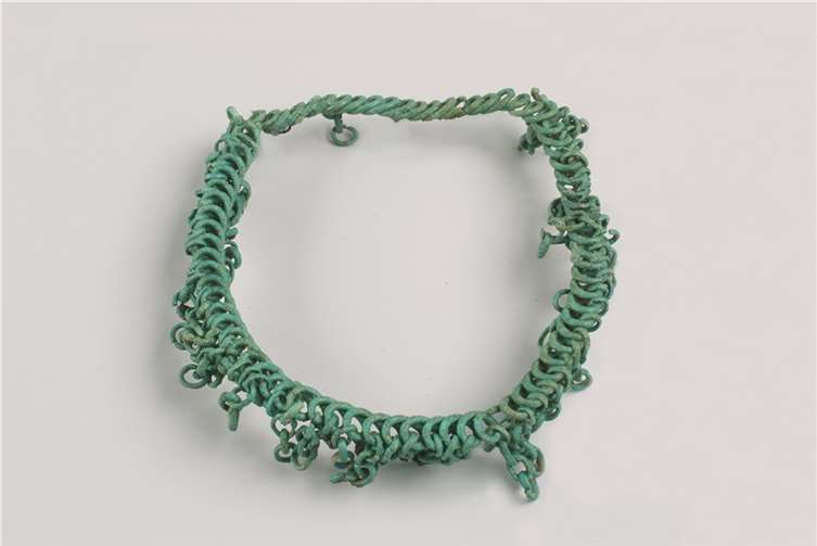 Eine Besonderheit ist der Spiraldrahthalsring mit einem inneren Durchmesser von ca. 12,5 cm. In die meisten Windungen sind Kettchen aus je vier offenen Ringen eingehängt. Foto: GDKE, Direktion Landesarchäologie, Außenstelle Koblenz / M. Neumann