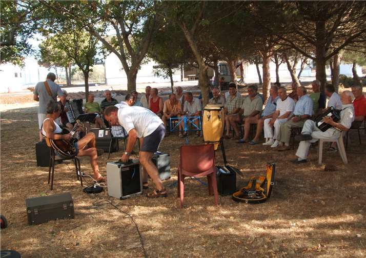 Eine Chorprobe unter Olivenbäumen.