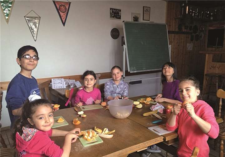 Eine Gruppe von Grundschulkindern bereitete sich einen Obstsalat zu. privat