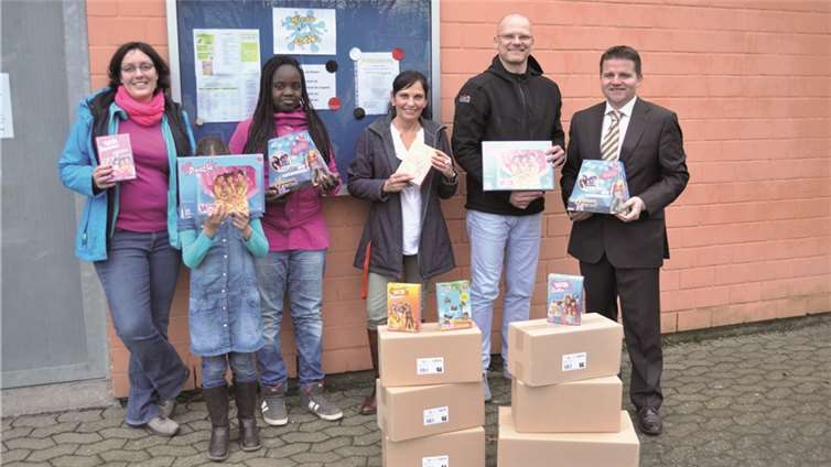 Eine Palette Spiele brachte Holger Schwan, Geschäftsführer von Projektservice Schwan, mit zum offiziellen Spiele-Spenden Übergabetermin an den Ersten Beigeordneten der Stadt Meckenheim, Holger Jung. Mit dabei auch Sibylle Rien, Leiterin von Kinder City und Margit Findeisen von der städtischen Jugendhilfe, sowie Mädchen von Kinder City. Stadt Meckenheim