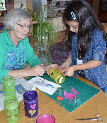Eine Patin hilft einem Kind beim basteln.privat