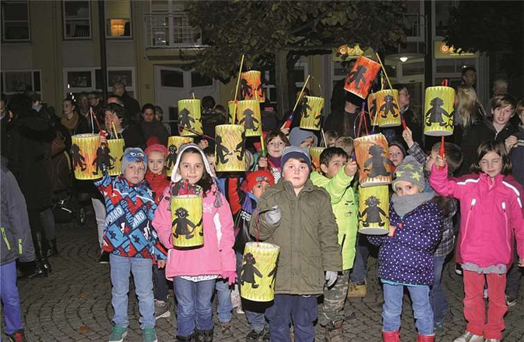 Eine Schulklasse präsentiert ihre leuchtend-schillernden Laternen.