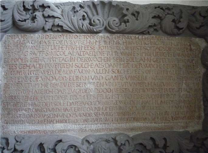 Eine Steintafel, die sich an der inneren Südwand der Pfarrkirche St. Nikolaus befindet.  F. G. Bell