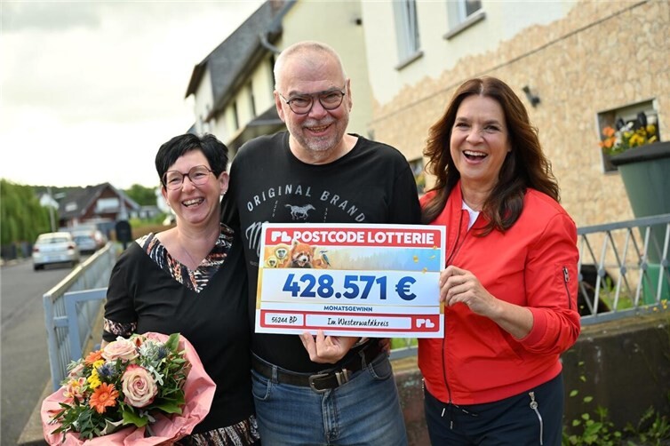 Eine gelungene Überraschung: Postcode-Gewinner Dirk und seine Ehefrau Alexandra freuen sich gemeinsam mit der internationalen Botschafterin der Postcode Lottery Group, Katarina Witt, über die höchste Gewinnsumme des Tages.