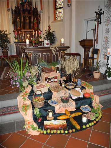Eine große Gabenvielfalt von Blumen, Brot und Wein, Obst und Früchte der Erde, selbst hergestellte Marmelade waren liebevoll vor dem Altar wie ein bunter Teppich zu sehen. Quelle: kfd Löf