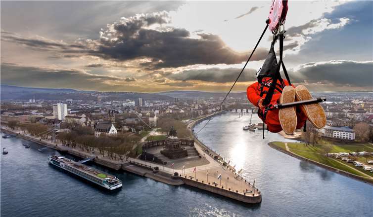 Eine neue Attraktion für Koblenz: Über eine Seilrutsche von der Festung Ehrenbreitstein fliegend über den Rhein bis hin zum Forum Confluentes. Foto: ©CL-Medien/stock.adobe.com, Montage: Koblenz-Touristik GmbH