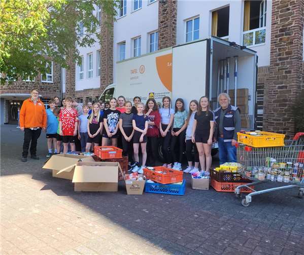 Einige Kisten Lebensmittel sowie Hygieneartikel haben die Schülerinnen und Schüler vom Gymnasium Calvarienberg für die Tafel Ahrweiler gespendet. Kuno Herchenbach (links) und Ekkehard Fiebrich (rechts) bedankten sich bei der Schülerschaft.  Foto: Christina Weber