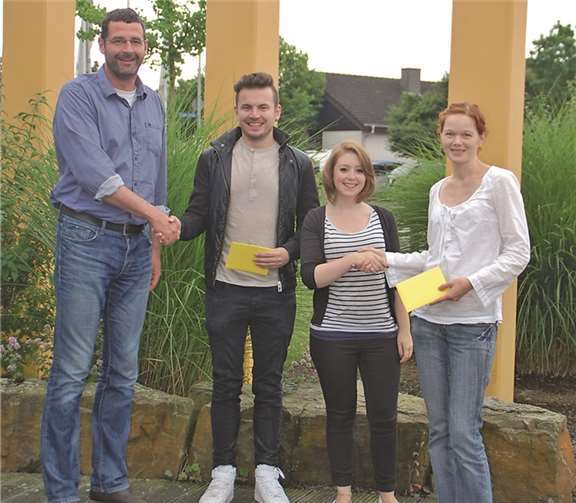 Einrichtungsleiter Frank Zenzen (li.) und Abteilungsleiterin Jana Kovac (r.) gratulieren Daniel Ott und Valerie Kniel zur erfolgreich bestandenen Abschlussprüfung mit einem Präsent. Caritas Werkstätten, Sinzig