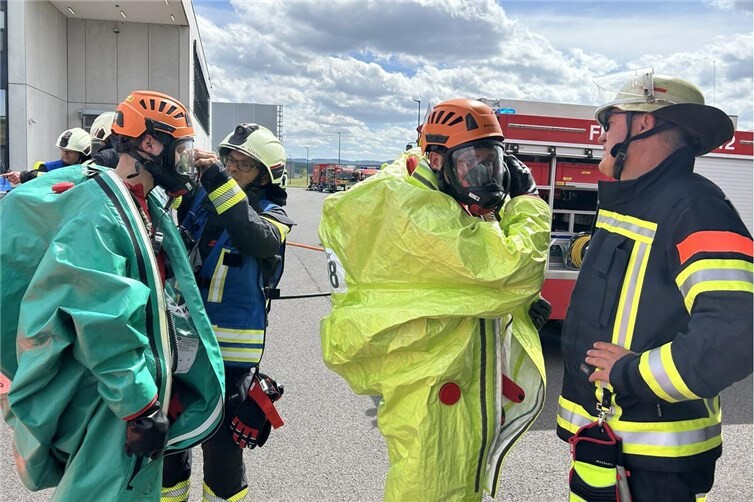 Einsatzkräfte beim Ausrüsten mit Chemikalienschutzanzügen