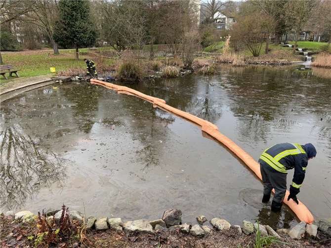 Einsatzkräfte bringen die Ölsperren zu Wasser