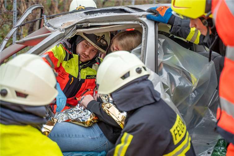 Einsatzkräfte von Feuerwehr und Rettungsdienst versorgen einen „Patienten“, um ihn anschließend gemeinsam aus dem Fahrzeug befreien zu können.  Foto: FF Ediger-Eller/Alexander Plattner
