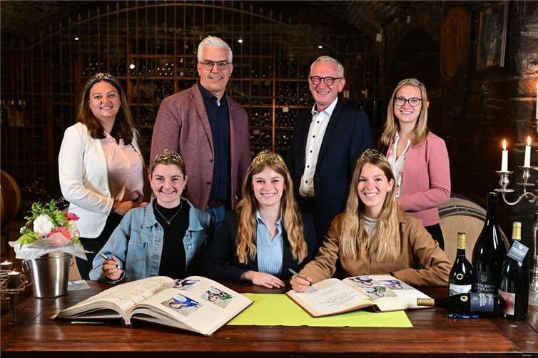 Eintrag in zwei Goldene Bücher in der Winzergenossenschaft Mayschoß/Altenahr: (v.l.) Ahrweinkönigin Annabell Stodden, die Deutsche Weinprinzessin Katharina Gräff, Bürgermeister Dominik Gieler, die Deutsche Weinkönigin Charlotte Weihl, Bürgermeister Guido Orthen, die Deutsche Weinprinzessin Julia Lambrich und Ahrweinprinzessin Laura Nietgen.  Foto: Martin Gausmann