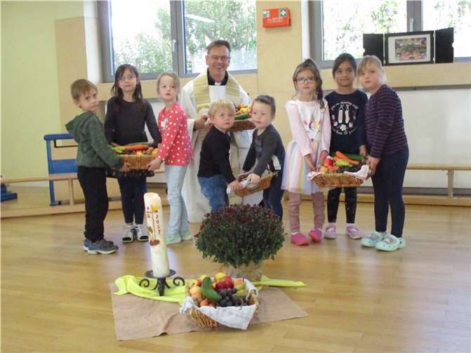 Einzelne Kinder mit Ernte in den Körben und ihrem Pastor Norbert Missong.  Foto: privat