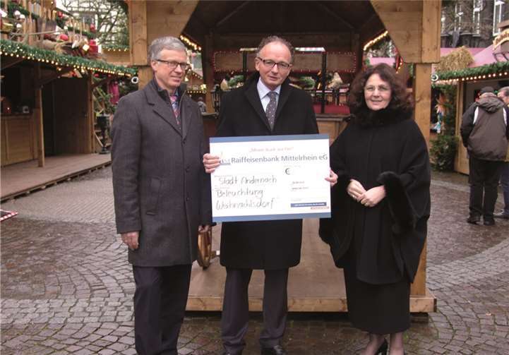 Elfi Rheinbay, Vorstand der Raiffeisenbank Mittelrhein eG, Oberbürgermeister Achim Hütten und Uwe Loscheider, Geschäftsstellenleiter der Raiffeisenbank Mittelrhein eG in Andernach bei der Scheckübergabe auf dem Adventsmarkt in Andernach. privat